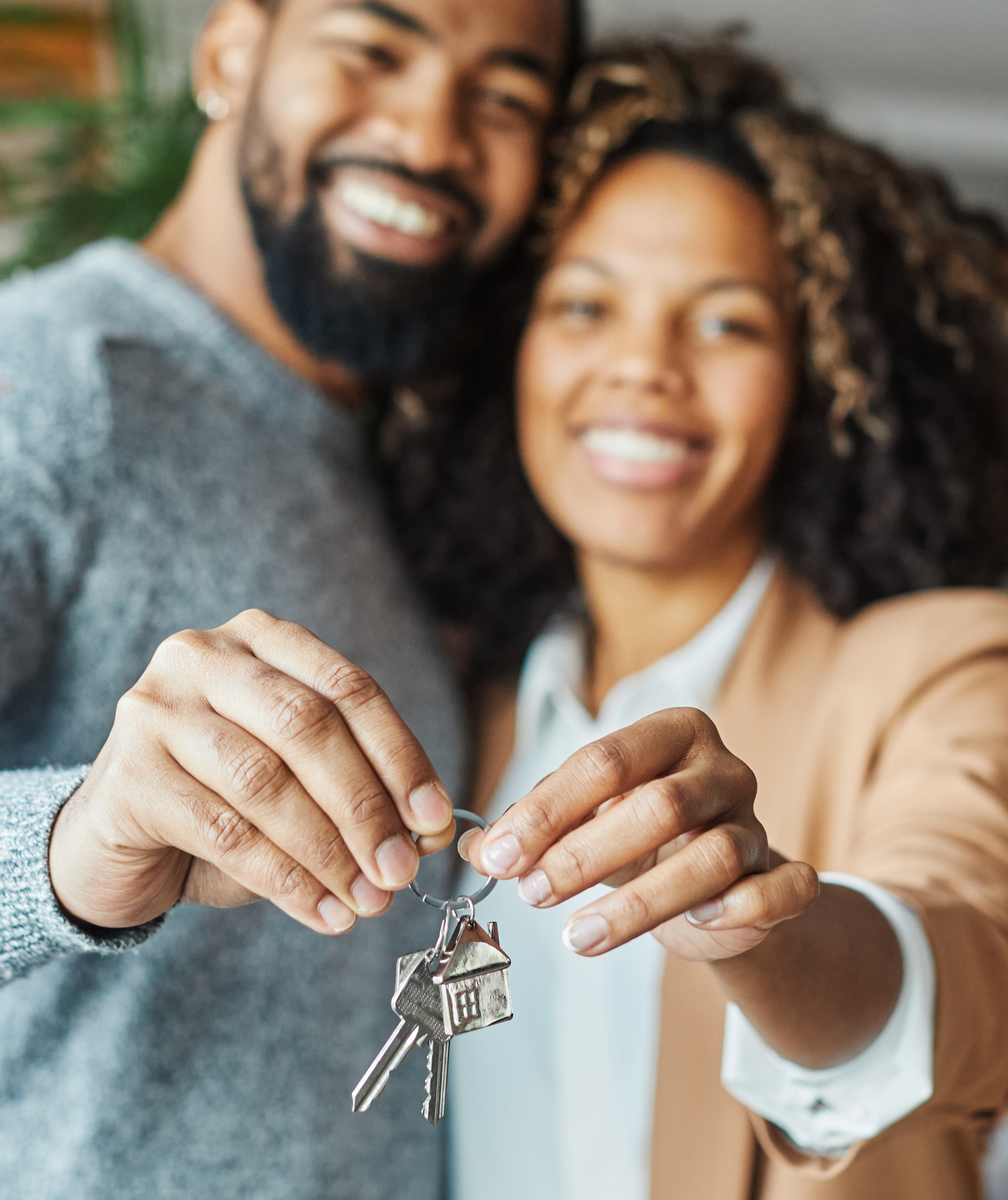 Couple holding keys smiling into camera