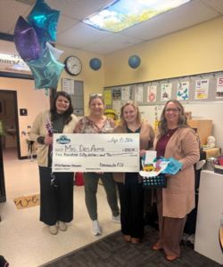 PFCU employees presenting a big check to Mrs. DesArmo