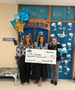 PFCU staff presenting Mrs. Gearhart with a big check for $250