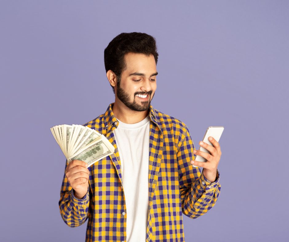 man holding cell phone and money