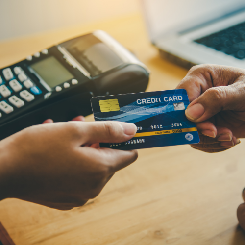 Two hands exchanging credit card for payment.